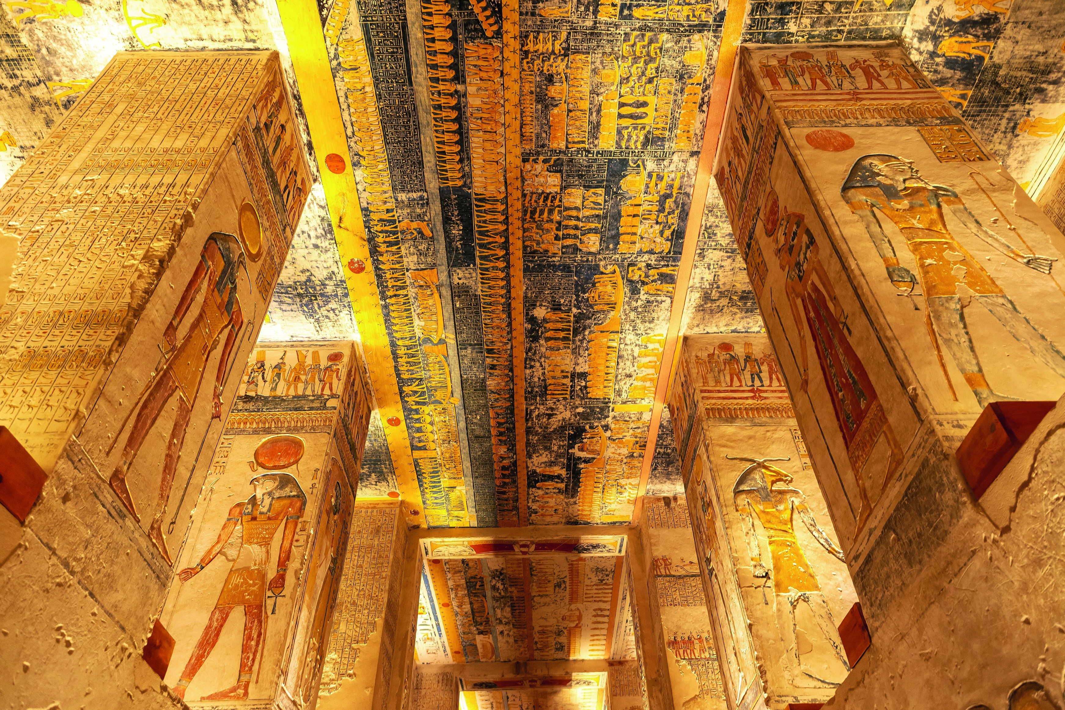 Deckenmalerei und Säulen mit ägyptischen Hieroglyphen und Figuren in einem historischen Tempel.