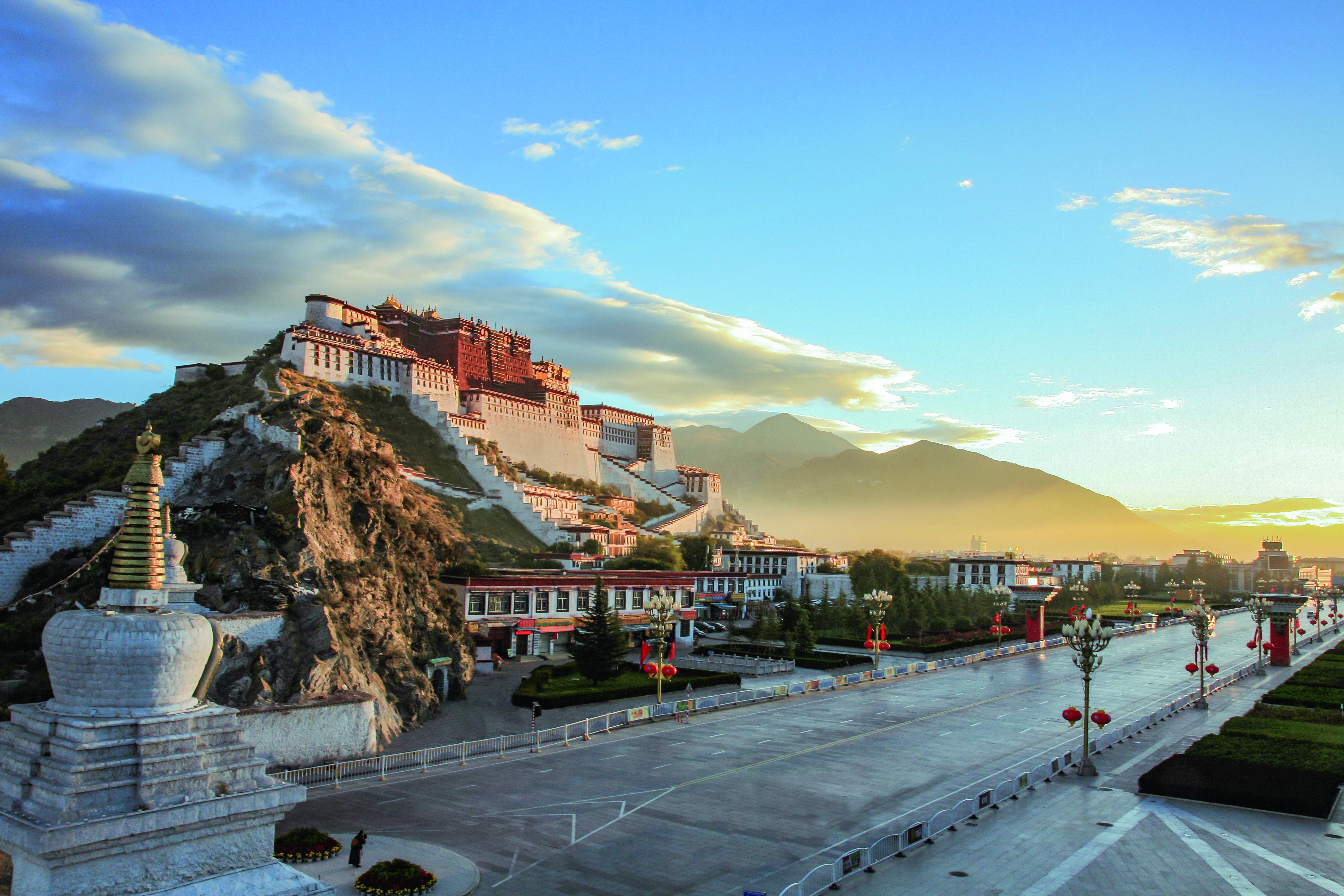 Der Potala Palast in Lhasa, Tibet, auf einem Hügel mit dramatischem Himmel und Sonnenlicht.