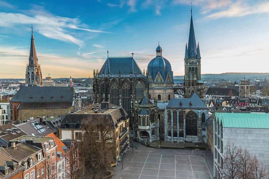 Aachener Dom mit markanten Türmen und Kuppel, umgeben von historischen Gebäuden in Aachen.