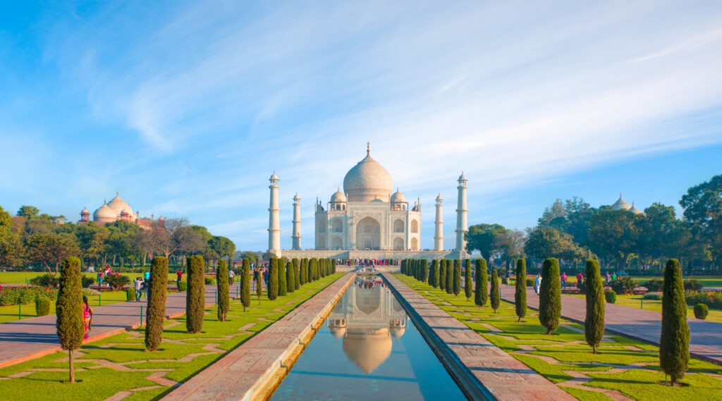 Taj Mahal in Indien mit reflektierendem Wasserbecken und gepflegten Gärten.