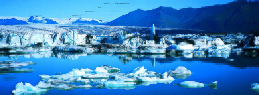 Panorama des Vatnajökull-Gletschers mit Eisbergen und reflektierendem Wasser in einer klaren blauen Umgebung.