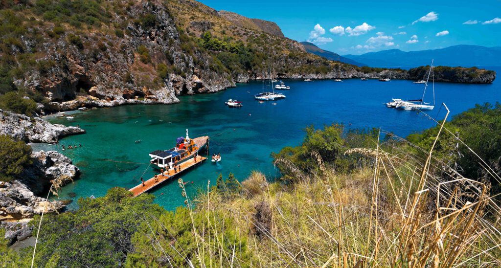 Blick auf den Hafen von Porto degli Infreschi mit Booten und klarem Wasser in einer malerischen Bucht.