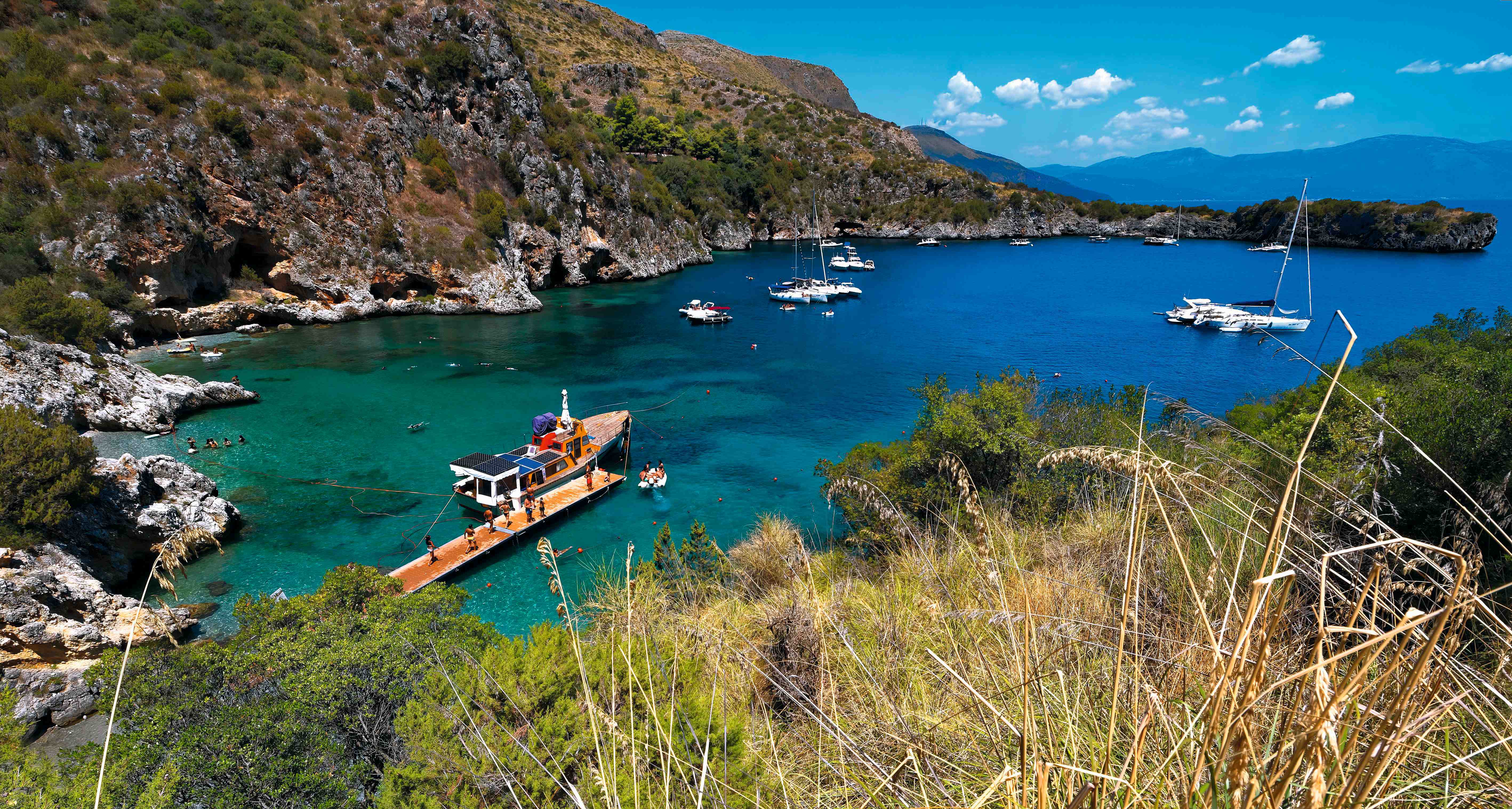 Blick auf den Hafen von Porto degli Infreschi mit Booten und klarem Wasser in einer malerischen Bucht.