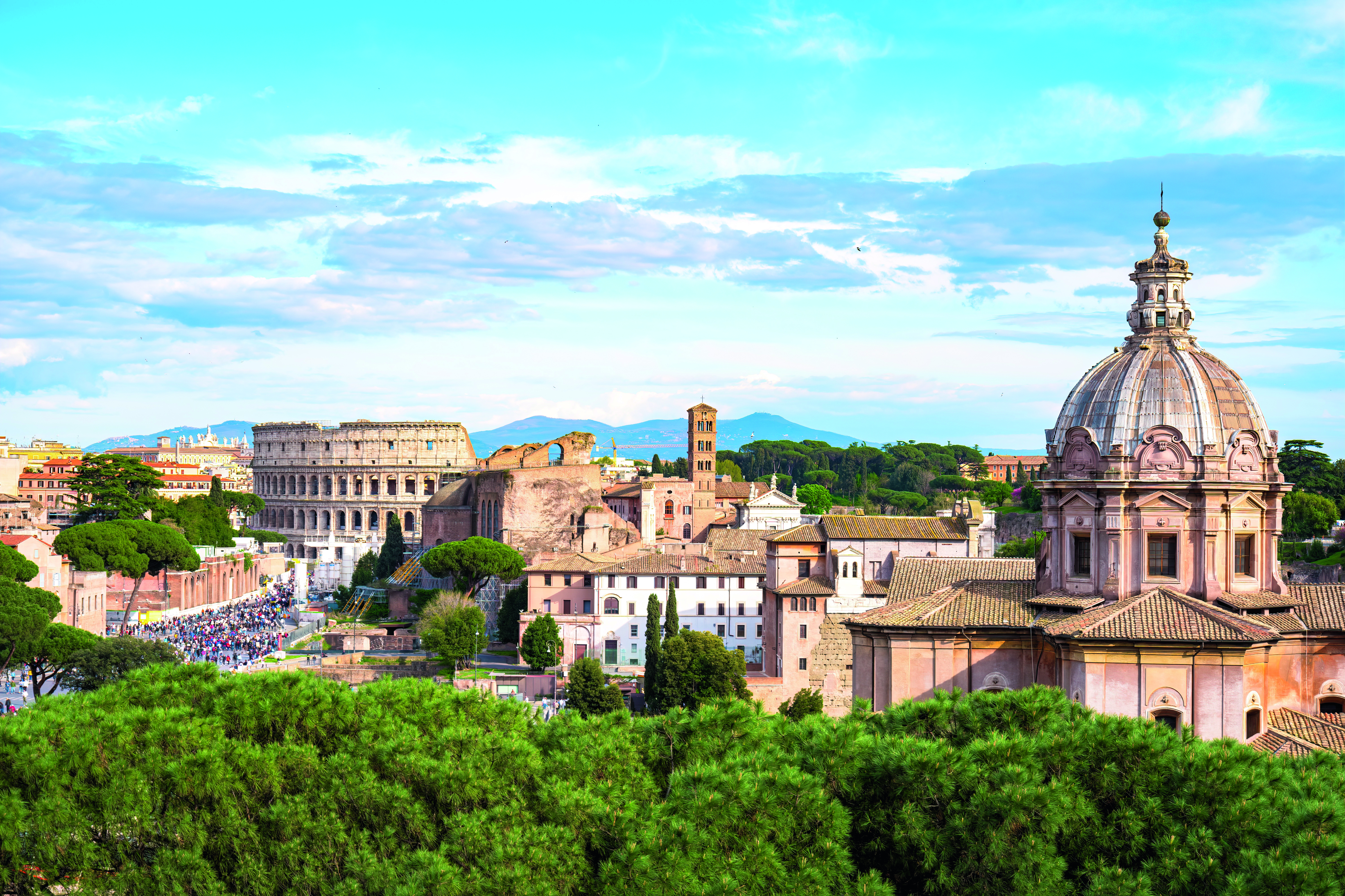 Panoramaansicht von Rom mit dem Kolosseum und historischen Gebäuden unter blauem Himmel.