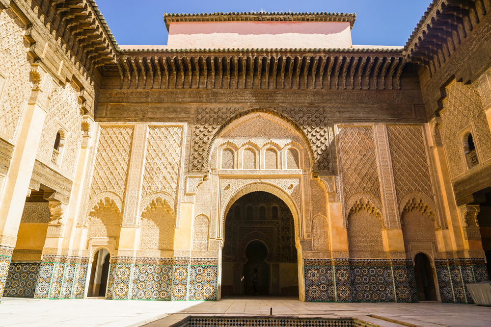 Architektur der Medersa Ben Youssef in Marrakesch mit kunstvollen Verzierungen und einem Innenhof.
