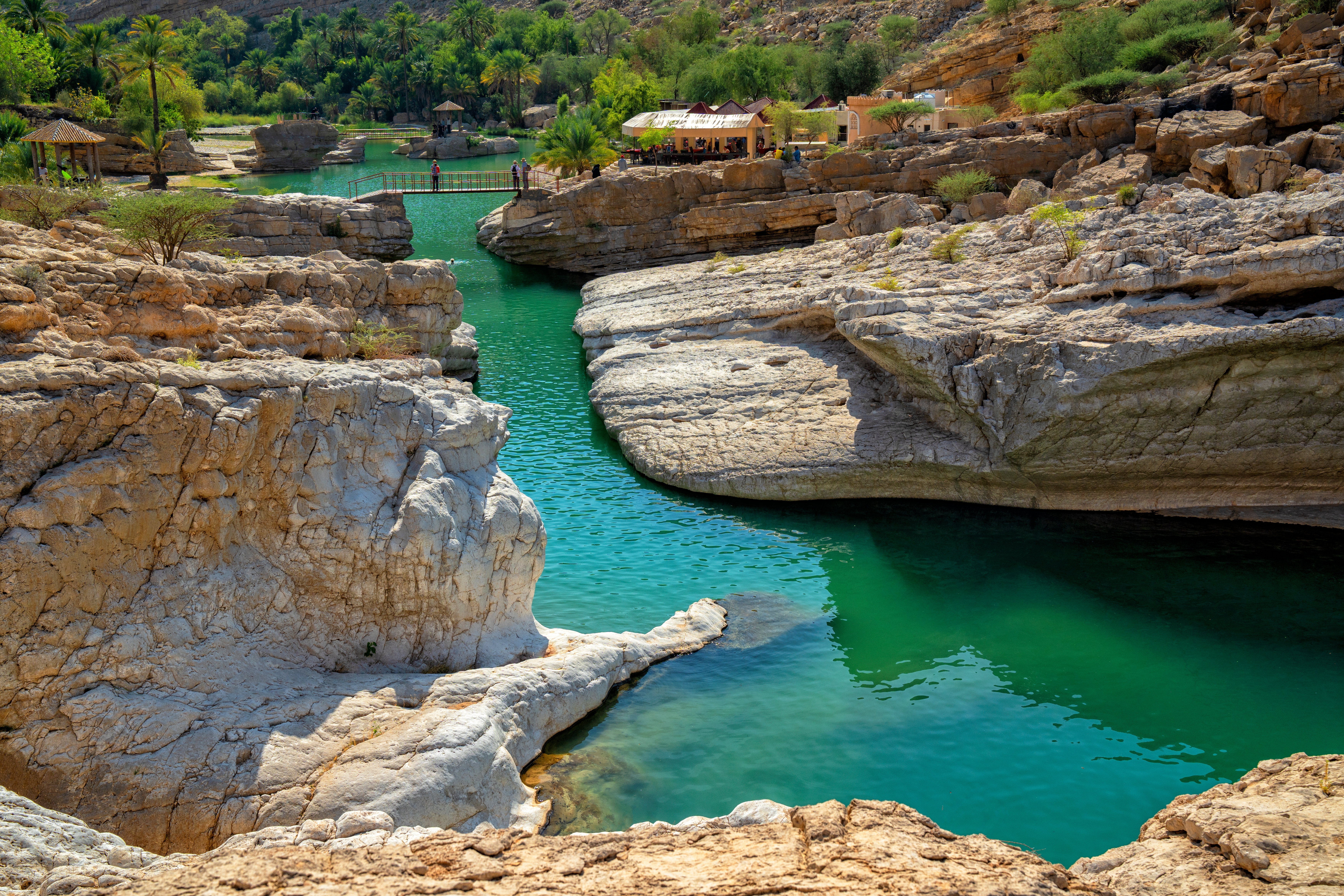 Wadi Bani Khalid mit klarem Wasser und Felsen in der Umgebung, ideal für Naturbeobachtungen.