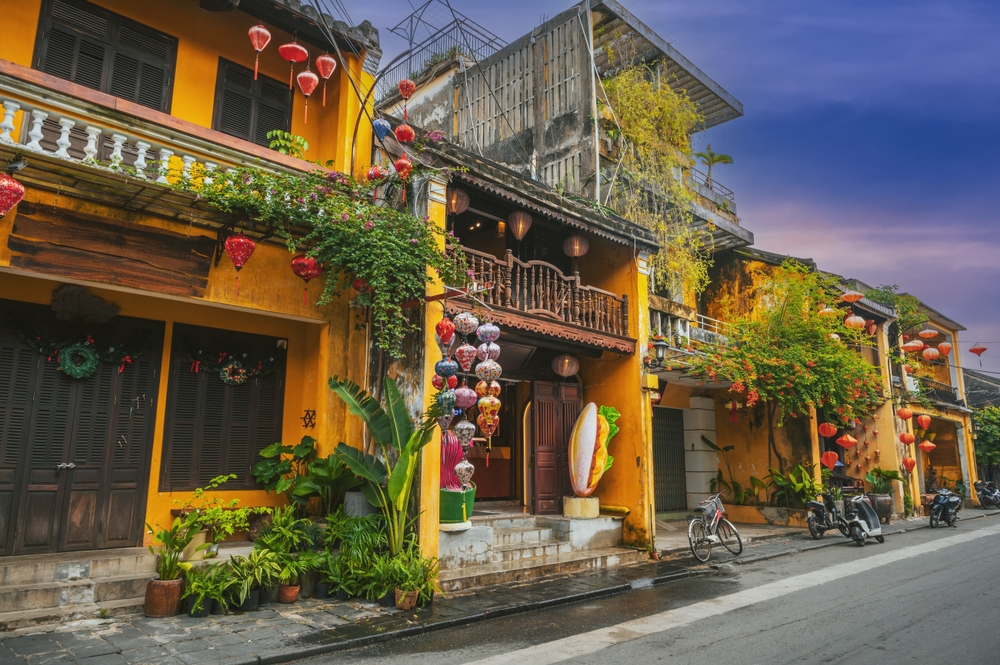 Bunte Häuser mit Pflanzen und Laternen in der Altstadt von Hoi An, Vietnam.