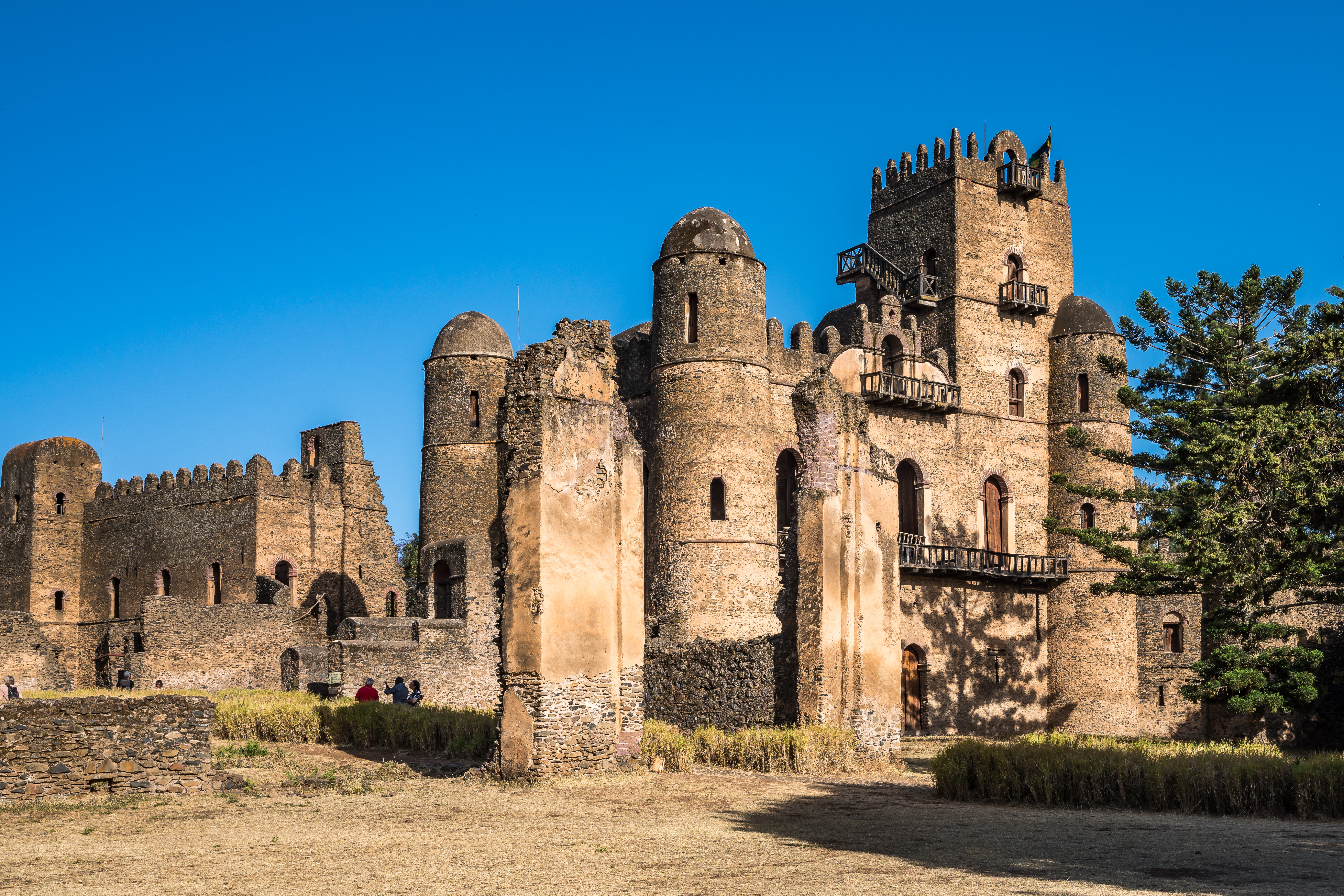 Historische Festung in Äthiopien mit mehreren Türmen und Mauern unter klarem blauen Himmel.