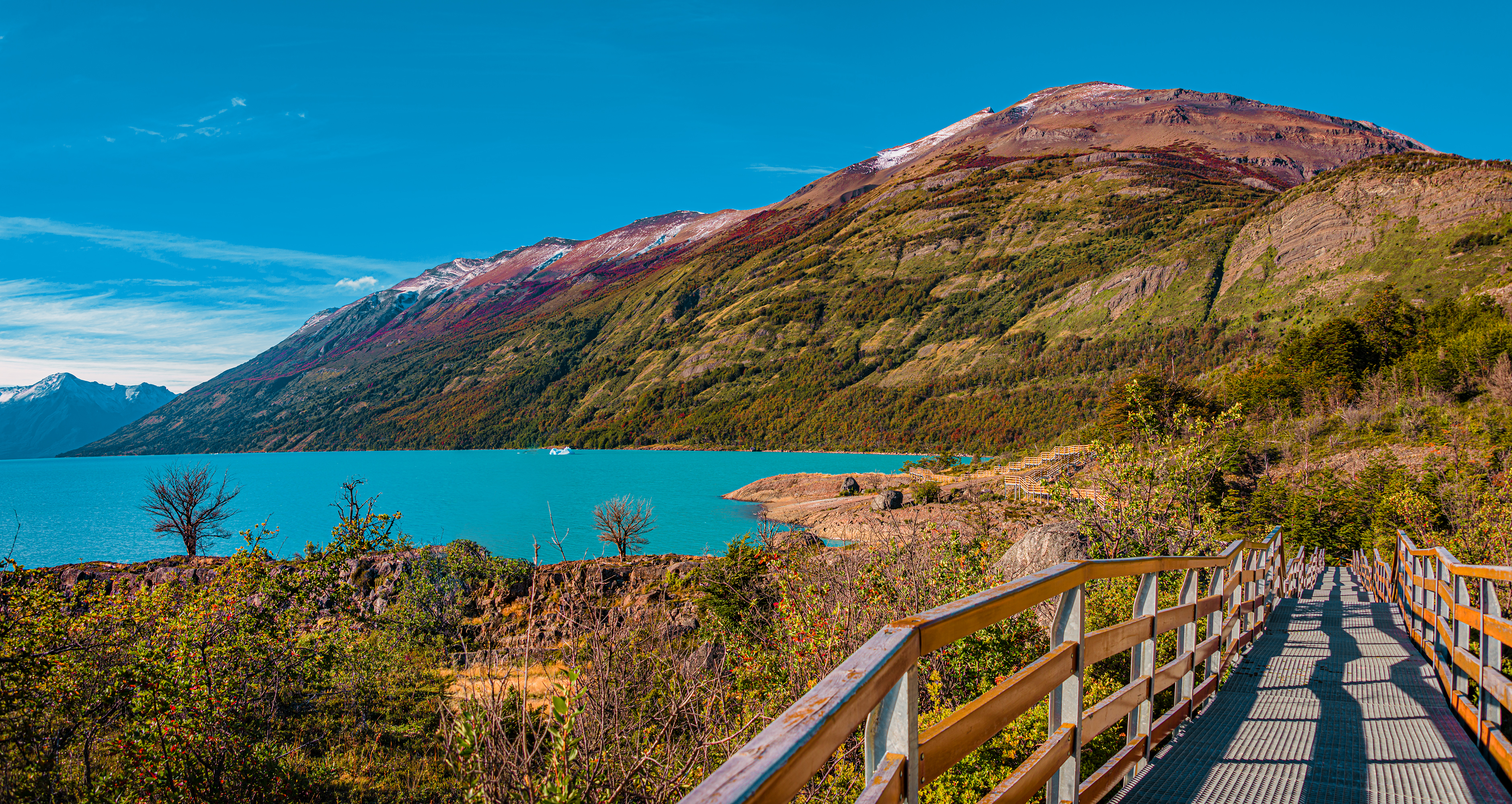 Blick auf eine malerische Landschaft mit Bergen, Wasser und einem Holzsteg in der Natur.