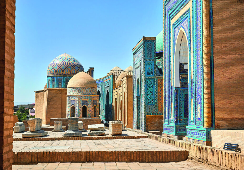 Architektonische Strukturen mit blauen Kuppeln und detaillierten Mosaiken in einer historischen Umgebung.