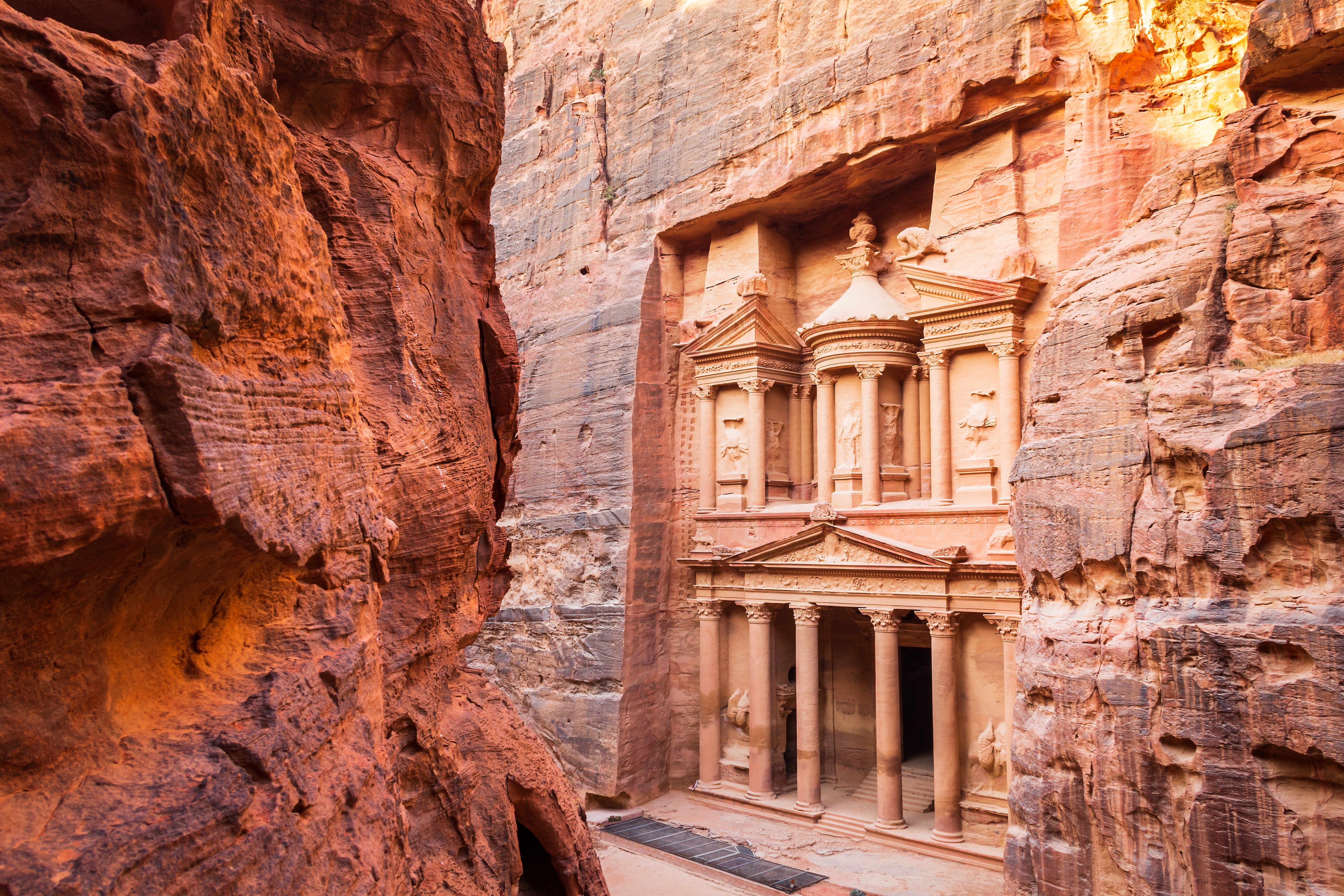 Die Fassade des Schatzhauses in Petra, umgeben von steilen Felswänden.