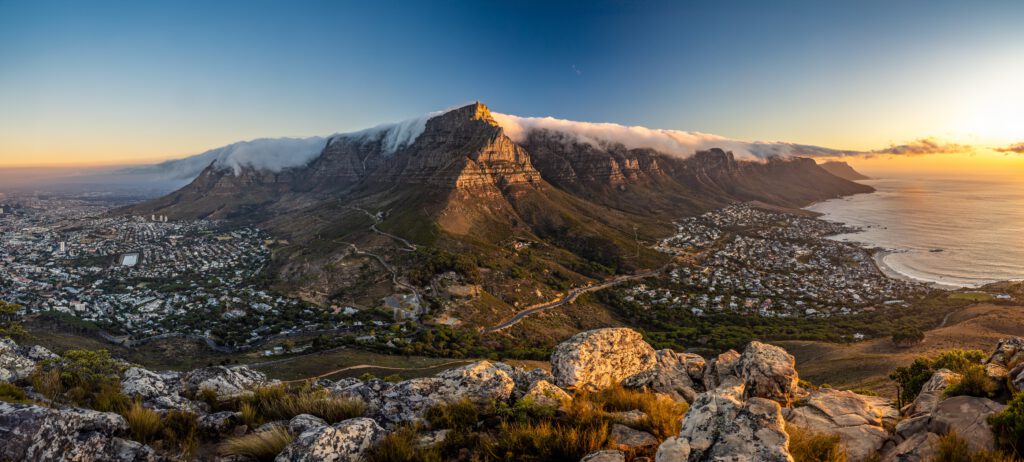 Panoramaaufnahme des Tafelbergs in Kapstadt mit Wolken und der Küste im Hintergrund.