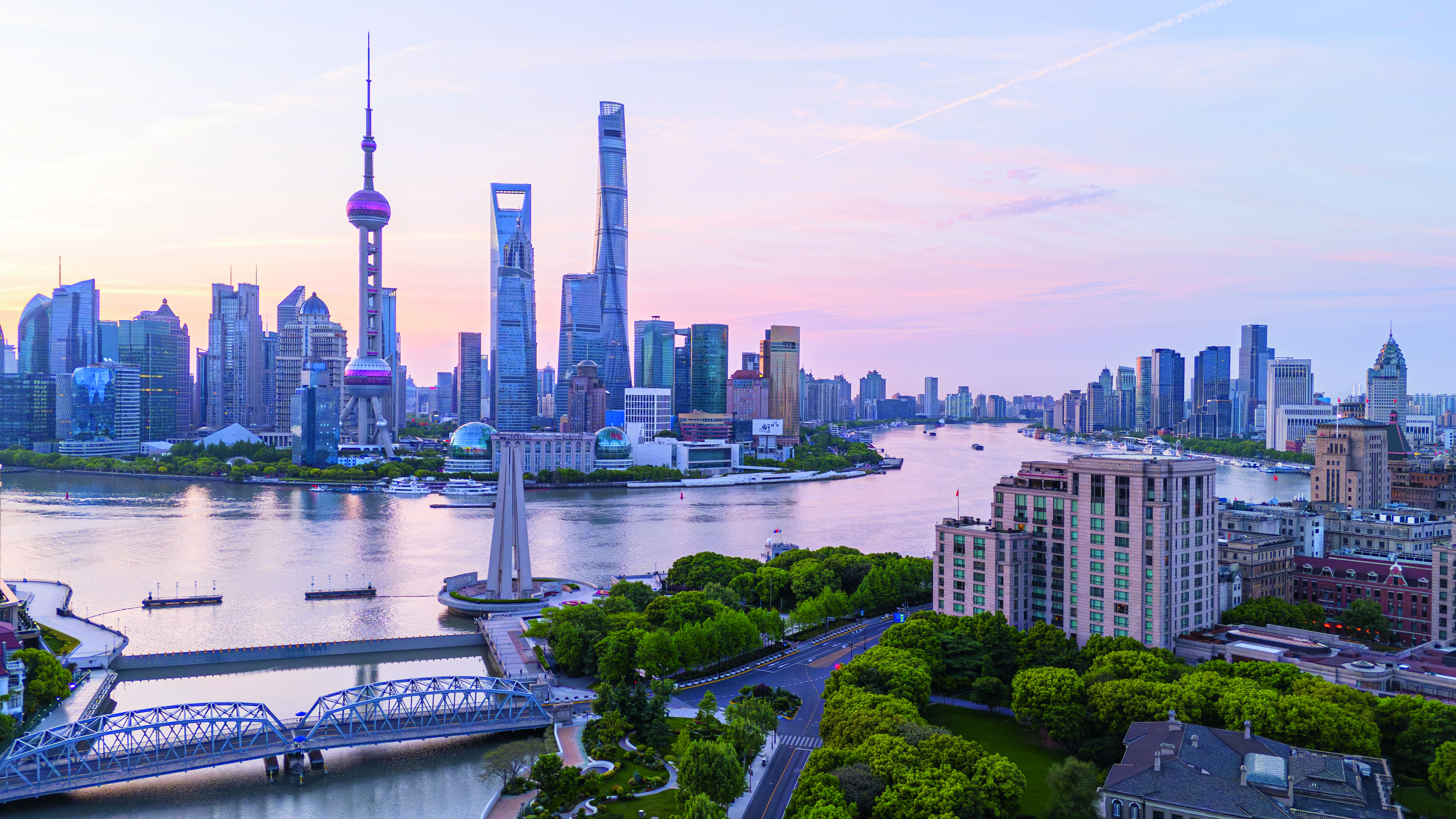 Panoramaansicht der Skyline von Shanghai mit dem Oriental Pearl Tower und dem Shanghai Tower bei Sonnenuntergang.