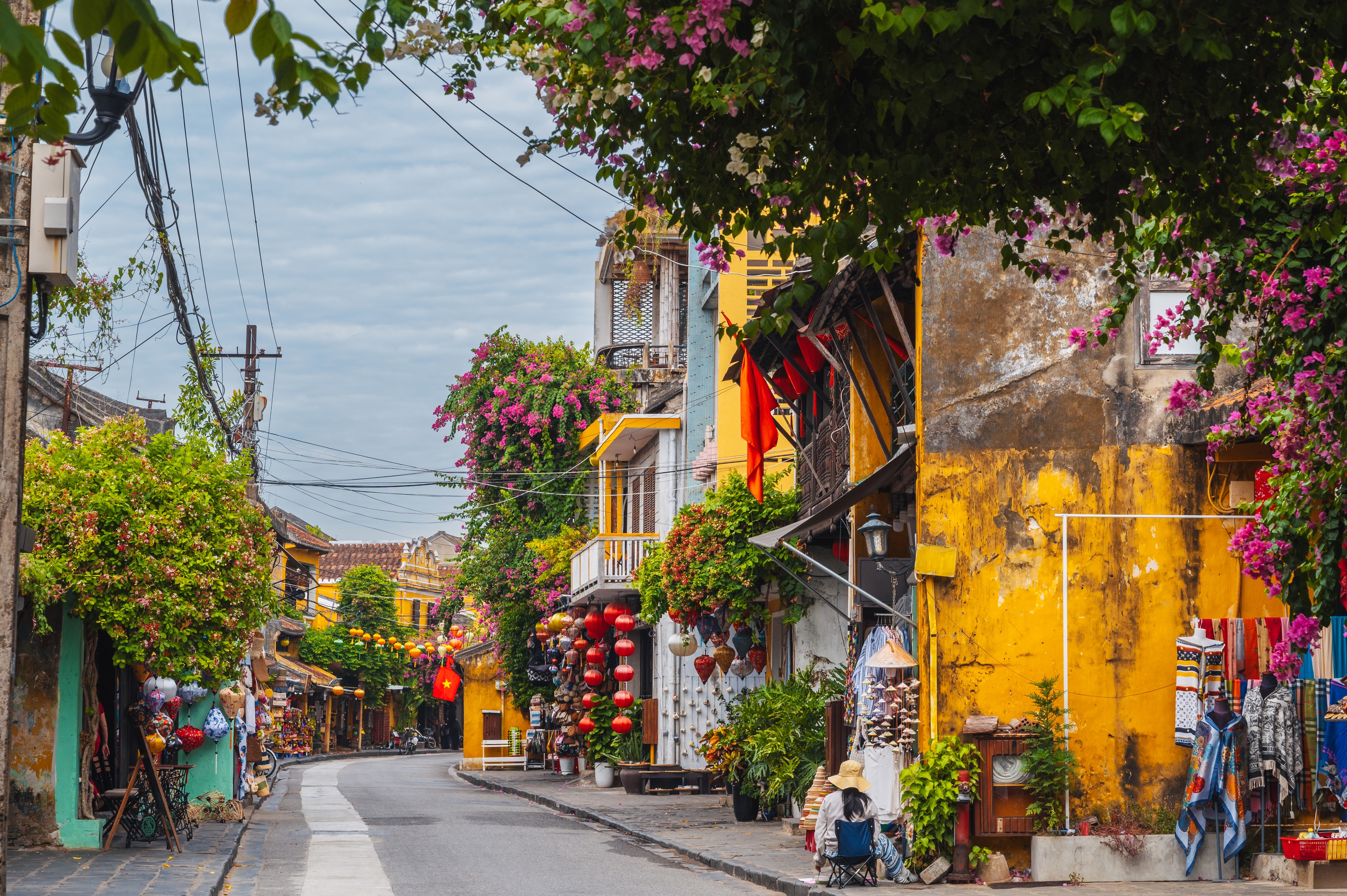 Bunte Straßenansicht mit gelben Gebäuden und blühenden Pflanzen in einer Stadt.
