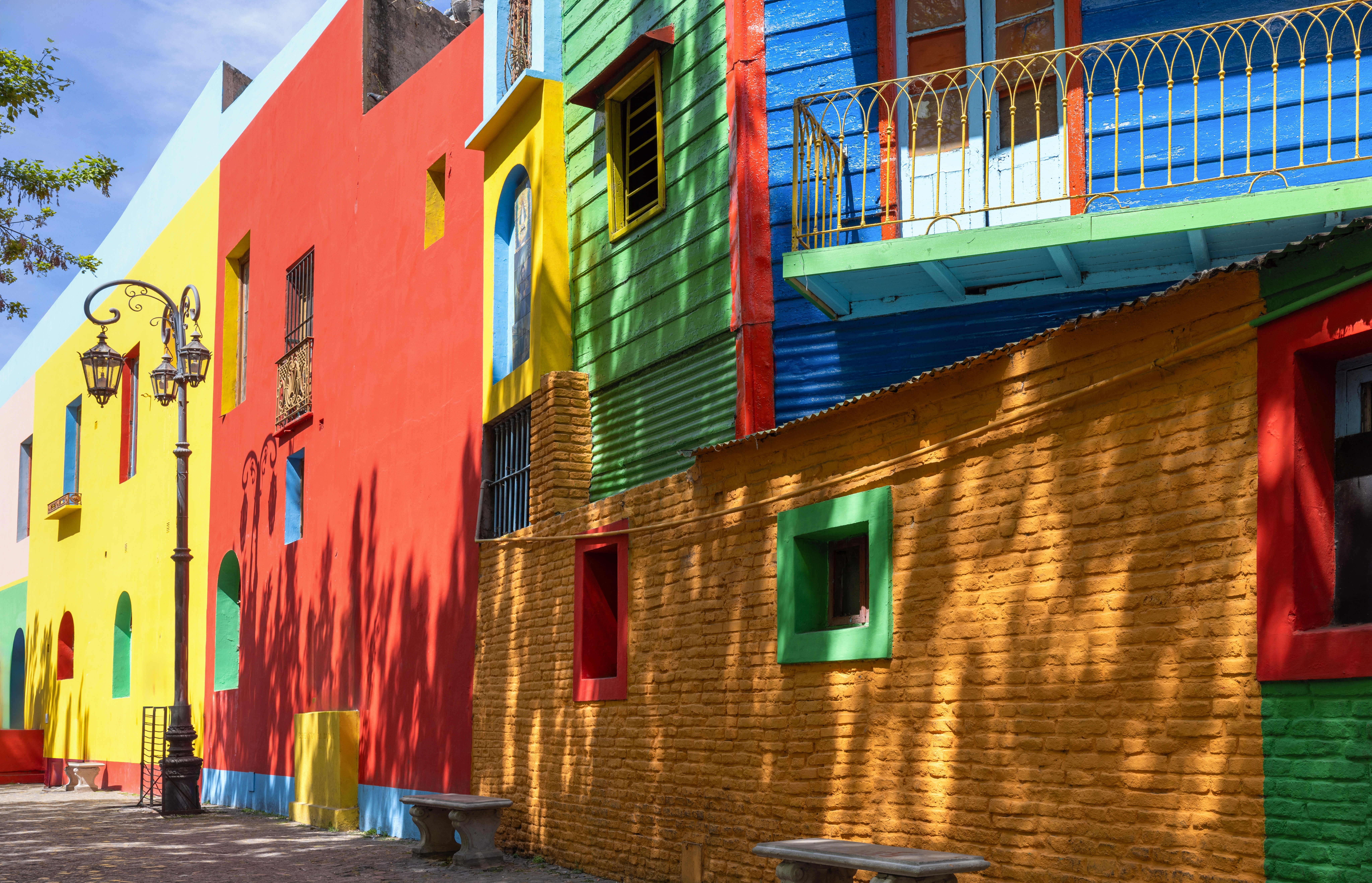 Bunte Wände in verschiedenen Farben, darunter Rot, Grün, Blau und Gelb, mit Fenstern und Balkonen.