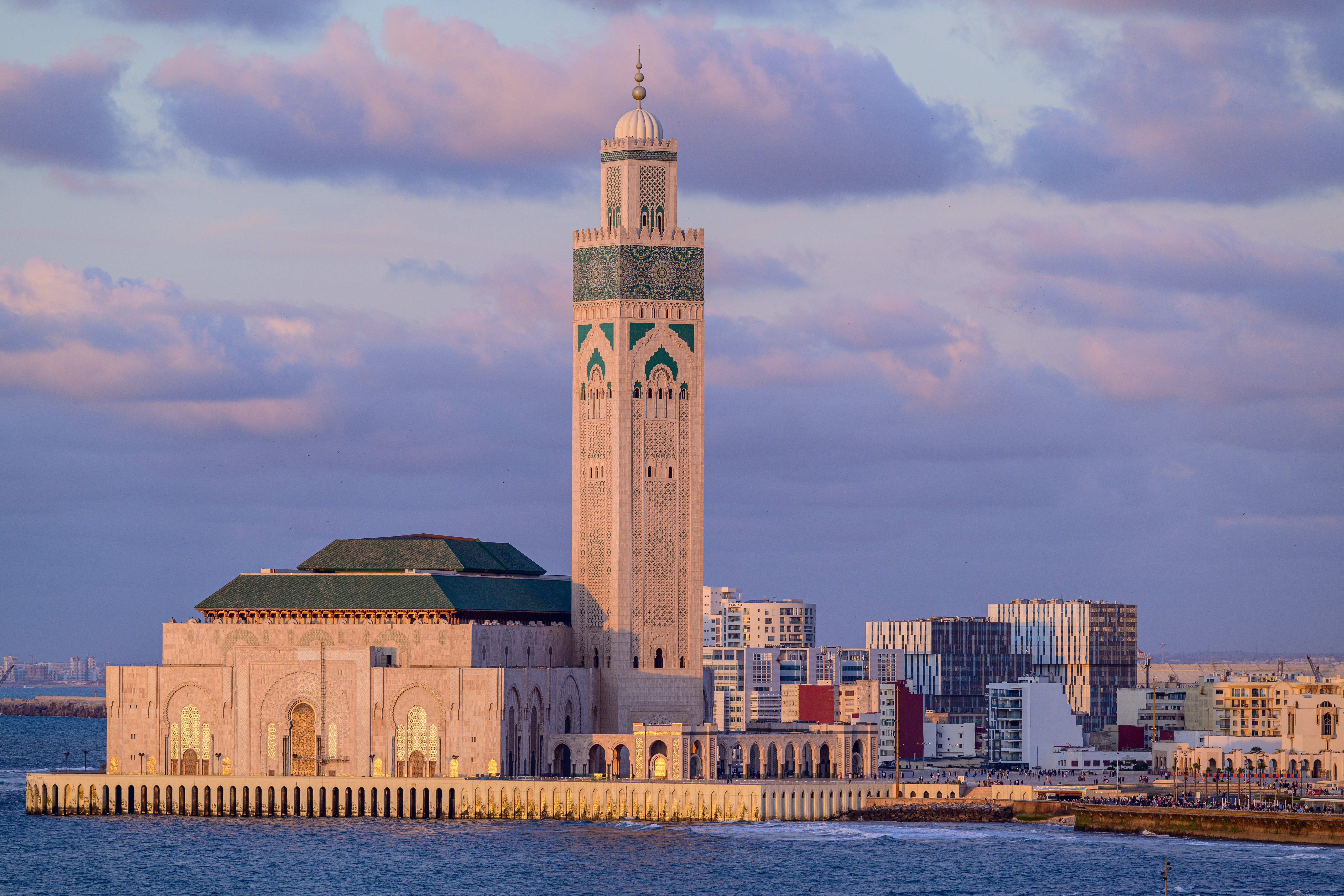 Die Hassan-II.-Moschee in Casablanca, Marokko, mit ihrem hohen Minarett und der umgebenden Küstenlandschaft.