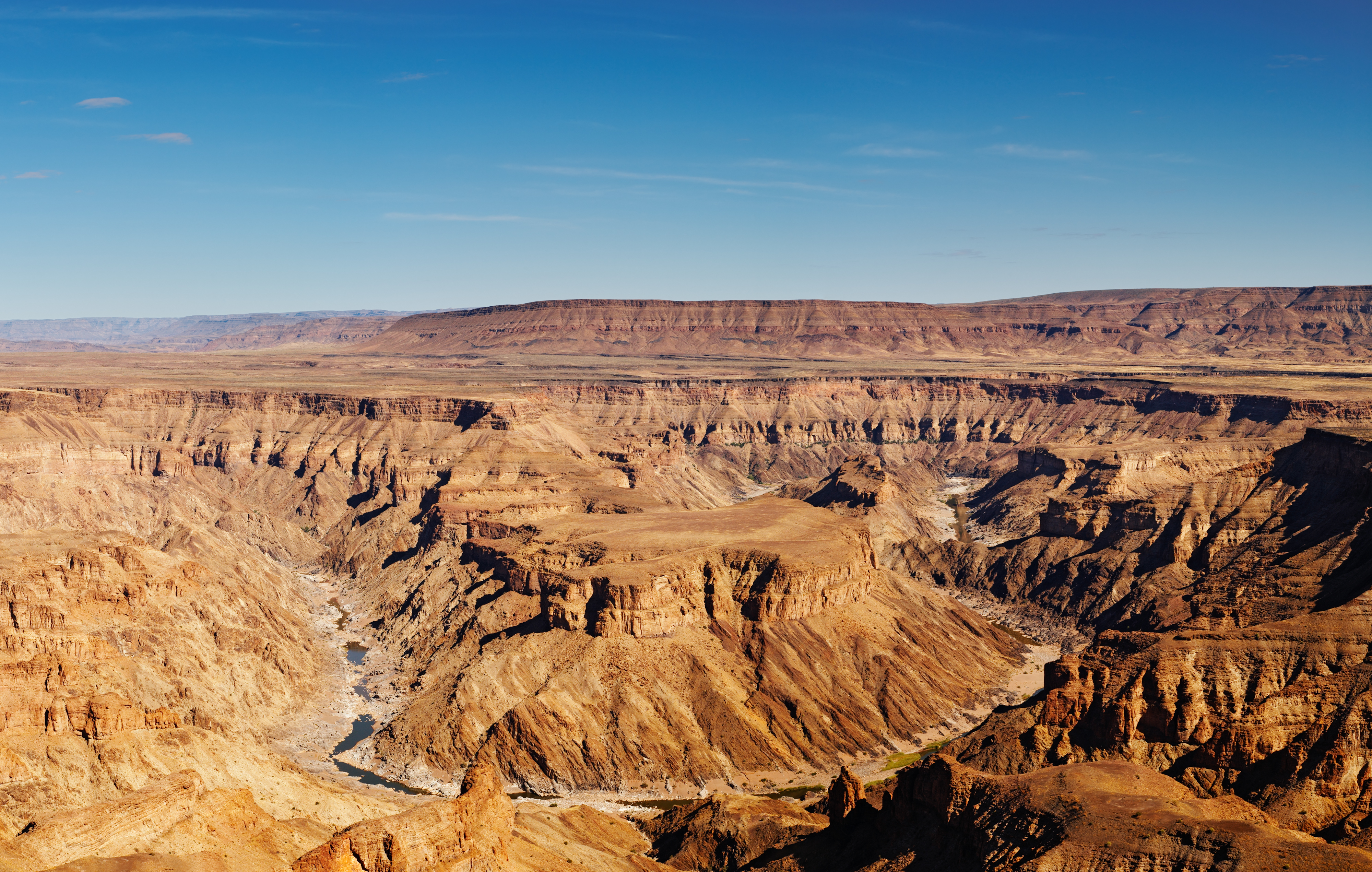 Blick auf die beeindruckende Landschaft des Fish River Canyon in Namibia mit seinen steilen Felsen und tiefen Schluchten.