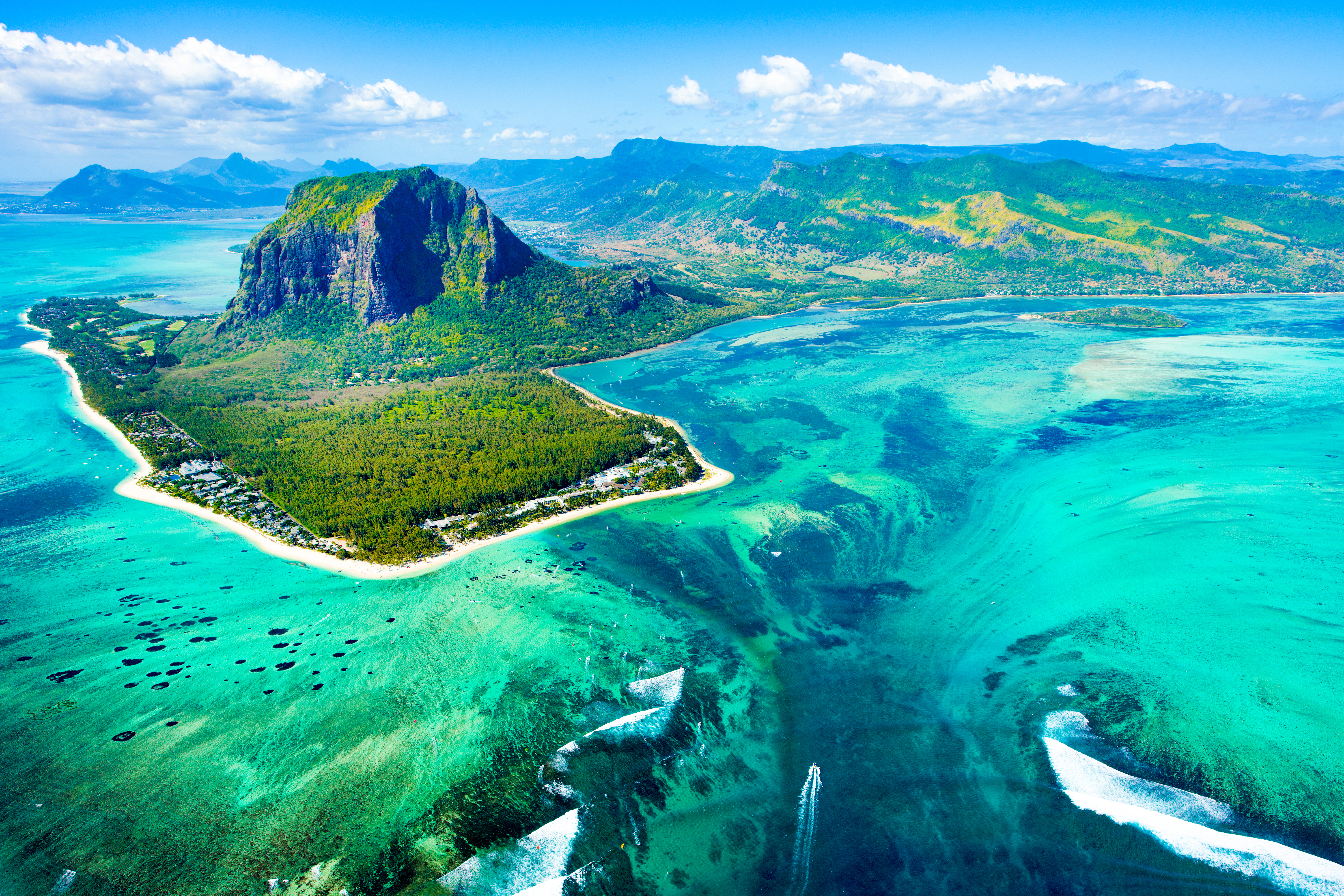 Luftaufnahme einer tropischen Insel mit grünem Berg und klarem, blauem Wasser in Mauritius.